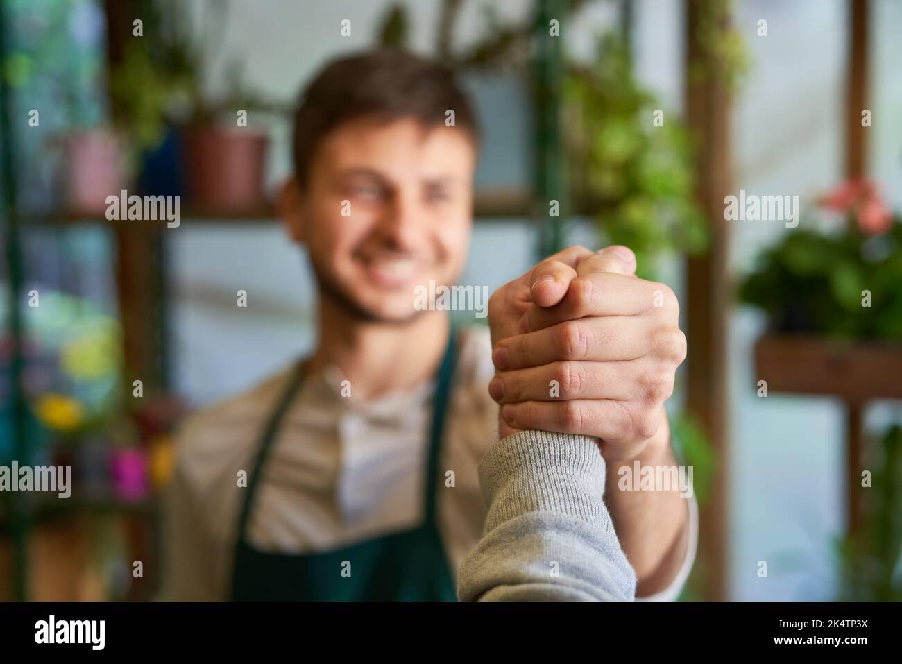 Young florist doing cool handshake as concept for cooperation and congratulation Stock Photo