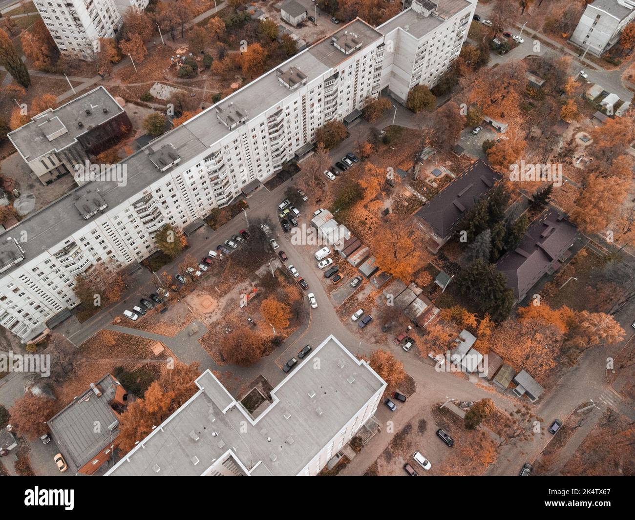 Aerial view on school and residential buildings in autumnal district. Fly above streets in autumn city. Treetop view on Kharkiv, Ukraine Stock Photo