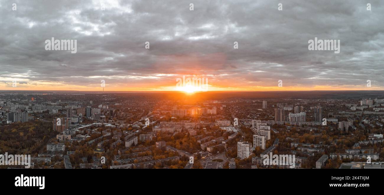 Aerial vivid autumn city sunset view with sun shine in gray clouds. Residential district buildings in evening light. Kharkiv, Ukraine Stock Photo
