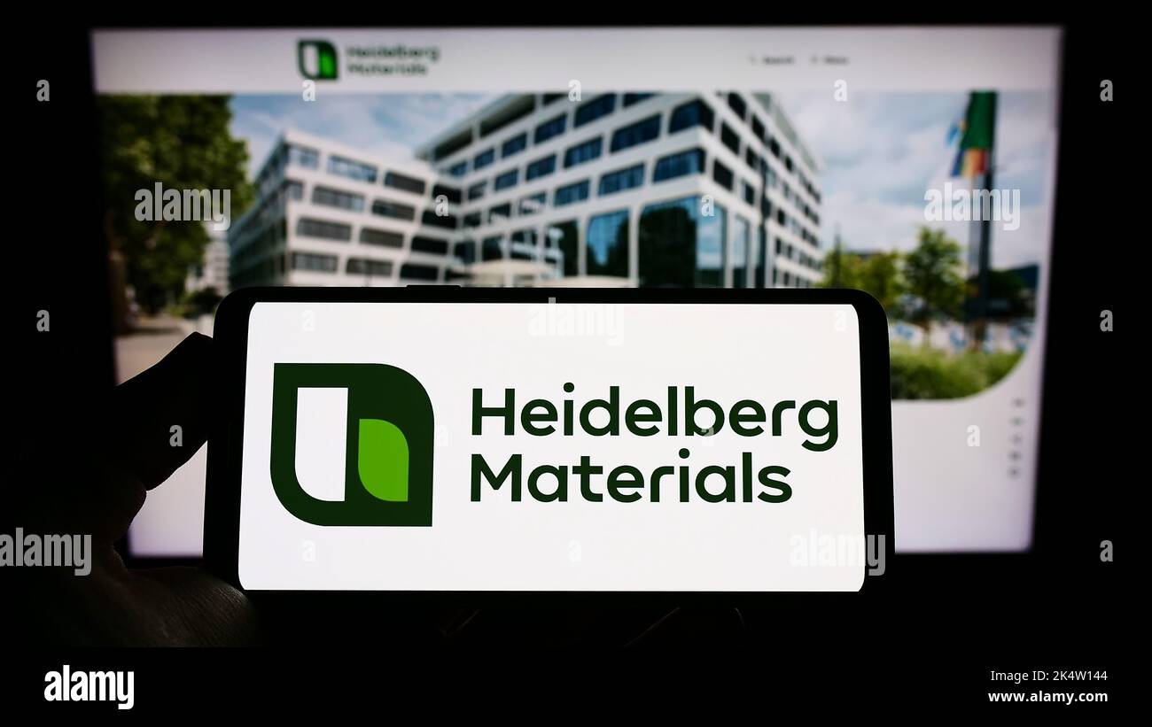 Person holding smartphone with logo of German company Heidelberg