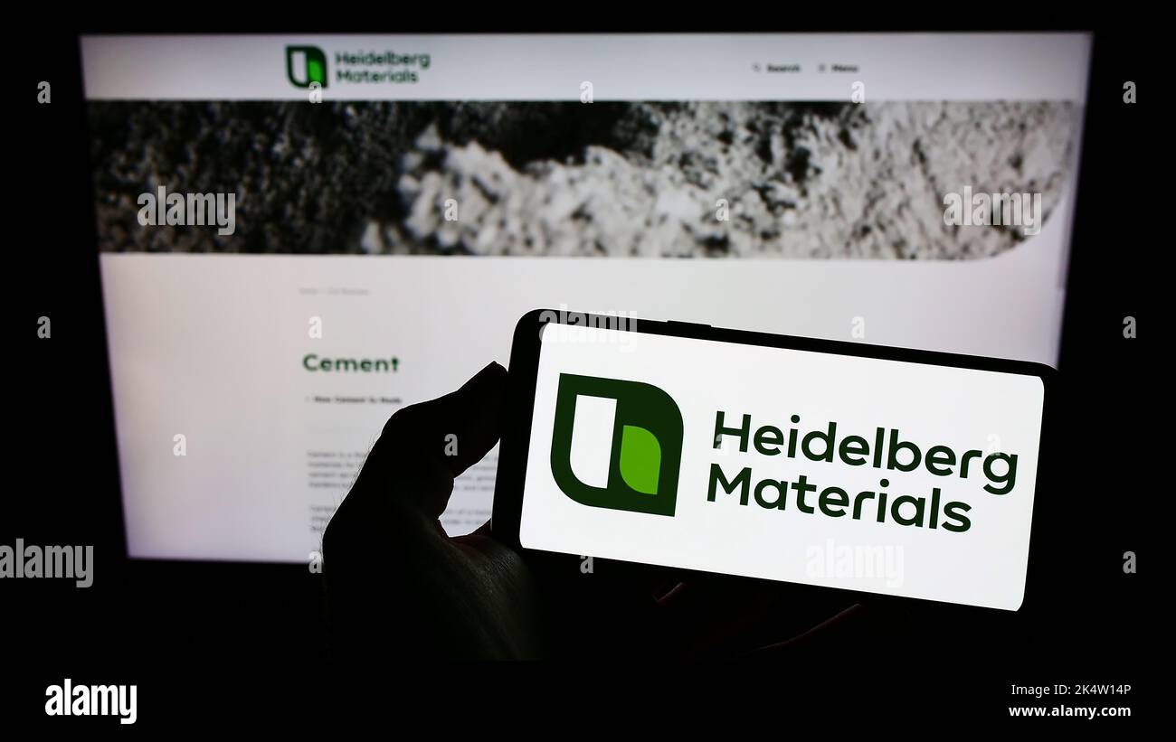 Person holding mobile phone with logo of German company Heidelberg