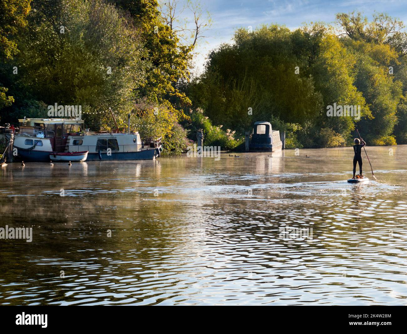 Paddle boarding must be the most daft way ever invented for getting about on water. It doesn't seem to bother this person though, doing her stuff on t Stock Photo