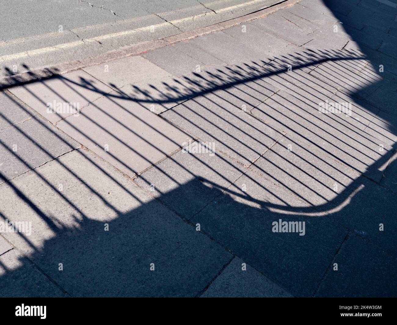 In the right time and place, even the everyday and ordinary can become fascinating. Take this abstract pattern on the pavement, the shadow of a decora Stock Photo