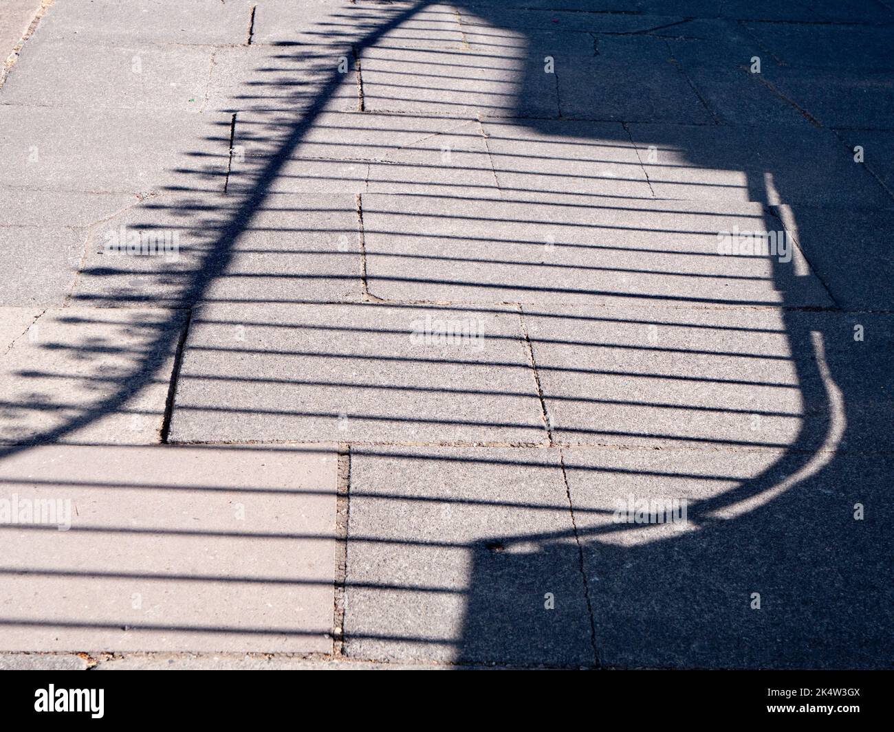 In the right time and place, even the everyday and ordinary can become fascinating. Take this abstract pattern on the pavement, the shadow of a decora Stock Photo