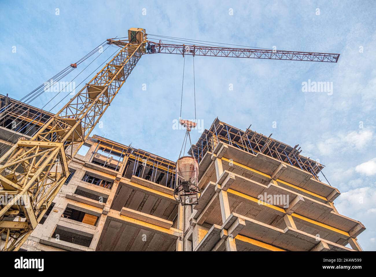 A low angle shot of a crane with equipment on a construction site with ...