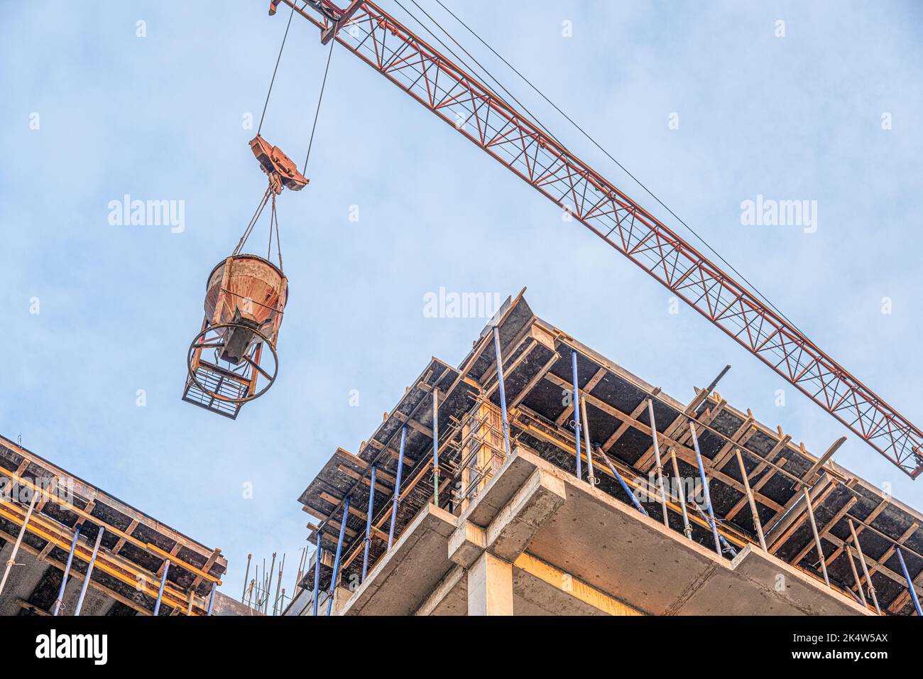 A low angle shot of a crane with equipment on a construction site with ...