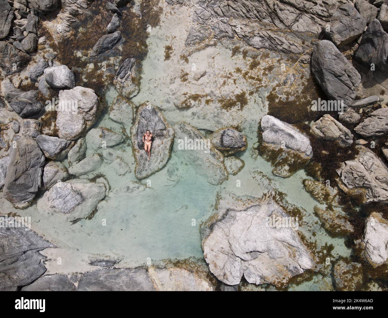 Woman resting on rocky stone hi-res stock photography and images - Alamy