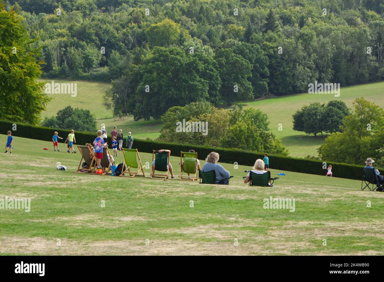 People outside in deckchairs on lawn of country house in Surrey, England Stock Photo