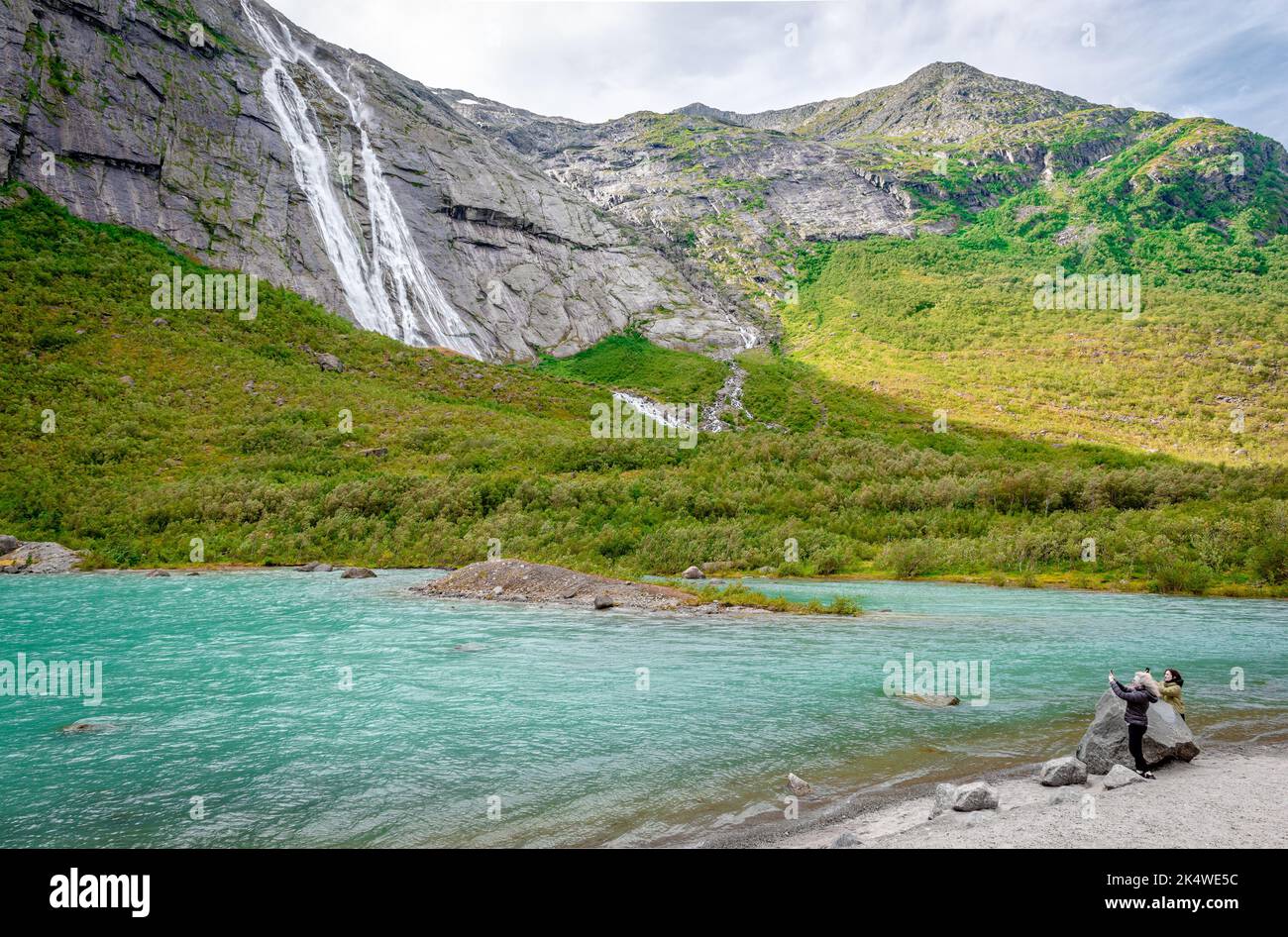 Briksdalen, Norway - August 22 2022: Women take photos of the magnificent Briksdalen valley, in Jostedalsbreen National Park, Norway. Scenic Norwegian Stock Photo