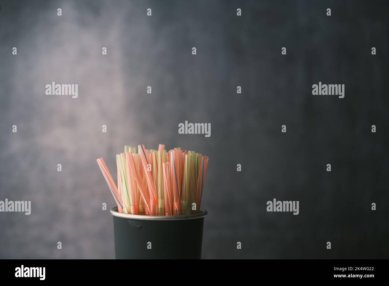 Colored striped bright plastic straws in a jar  Stock Photo