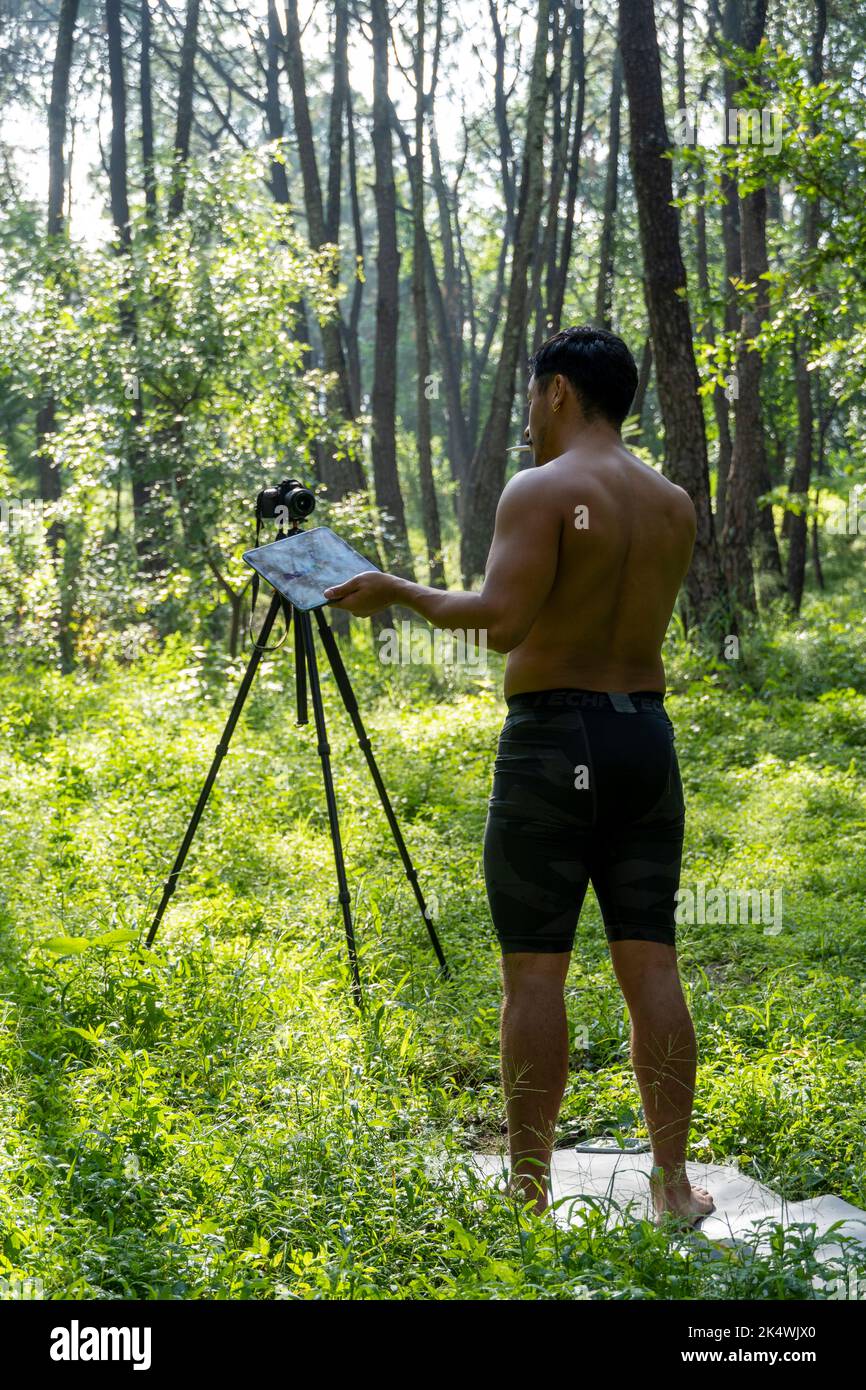 Guy with tablet making video blog on phone. Isolated person giving online classes. Man giving online classes with phone. Stock Photo