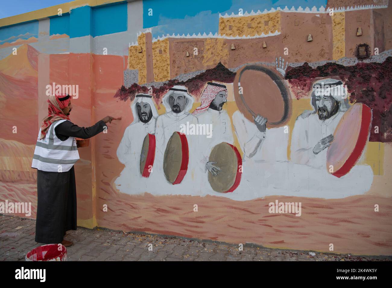 Arab man painting mural on wall Hail Saudi Arabia Stock Photo