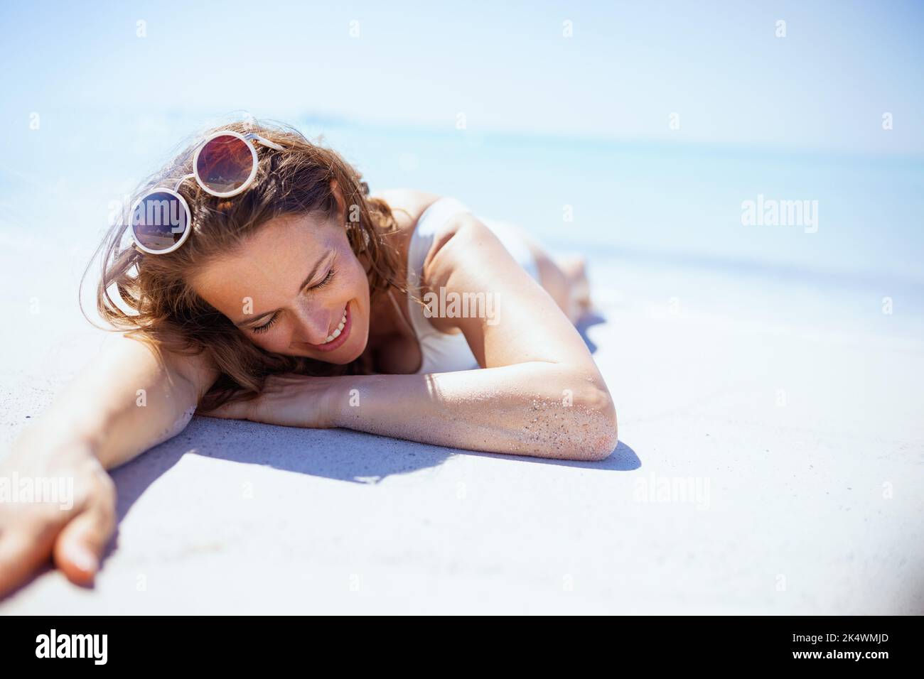 happy stylish middle aged woman laying at the beach Stock Photo - Alamy