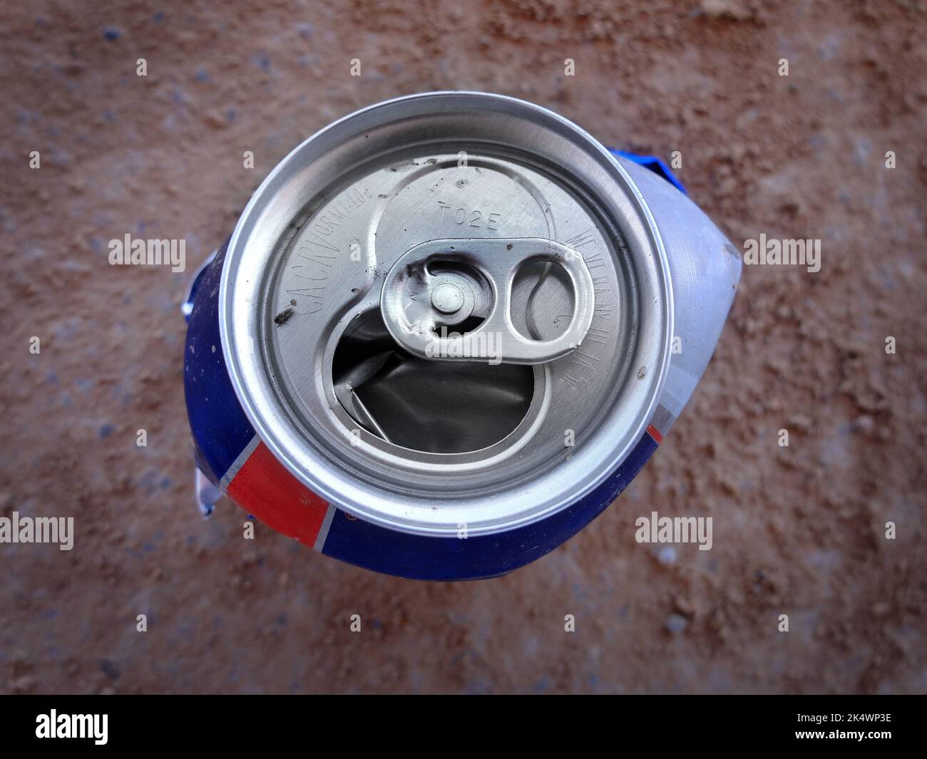 Crushed can on ground and dirst as trash and litter Stock Photo