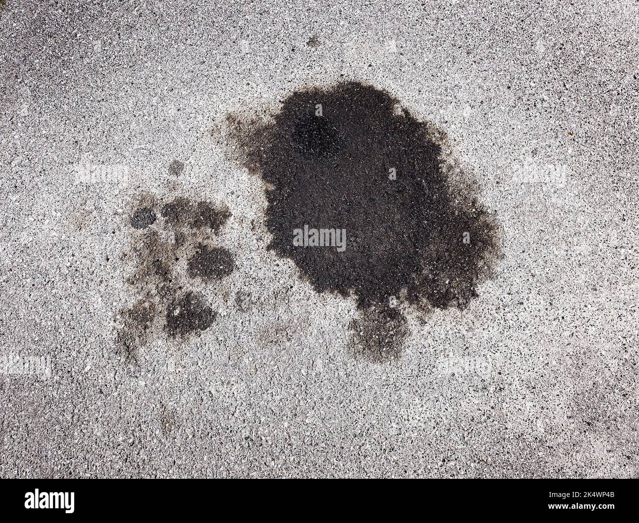 Oil spill spilled from car on roadway parking area Stock Photo