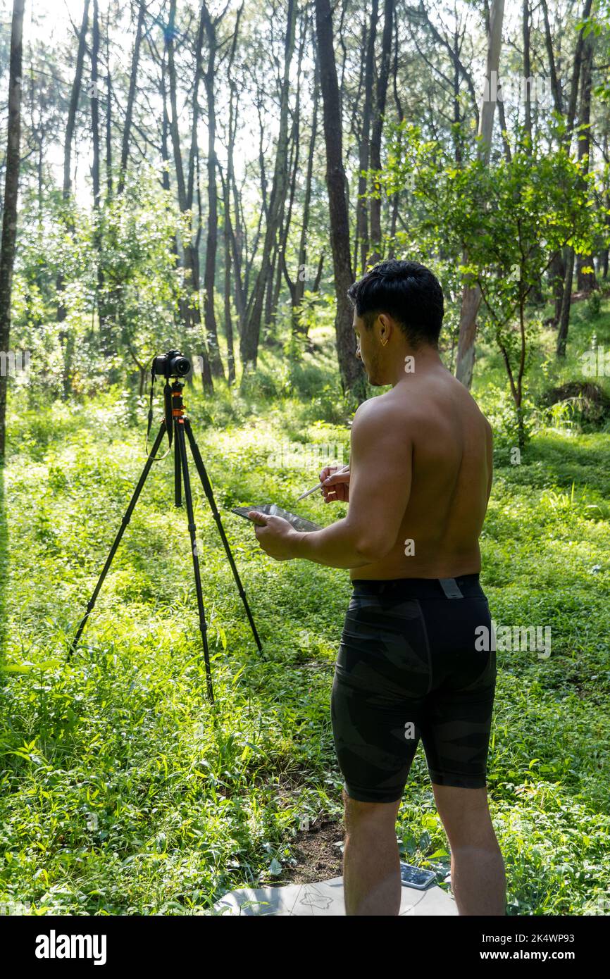 Guy with tablet making video blog on phone. Isolated person giving online classes. Man giving online classes with phone. Stock Photo