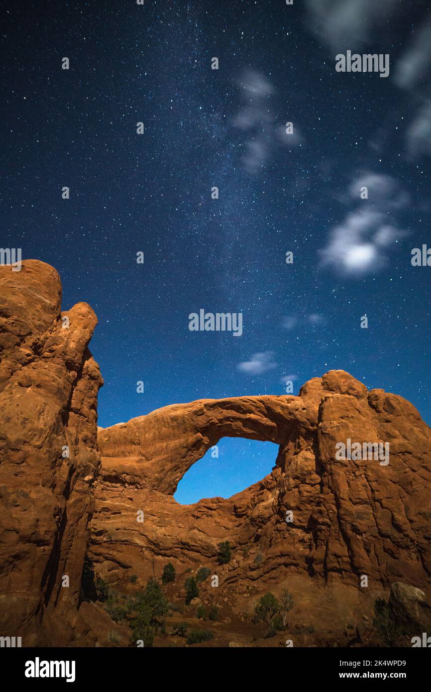 Stars and clouds over the South Window lit by light painting.  WIndows Section, Arches National Park, Moab, Utah. Stock Photo