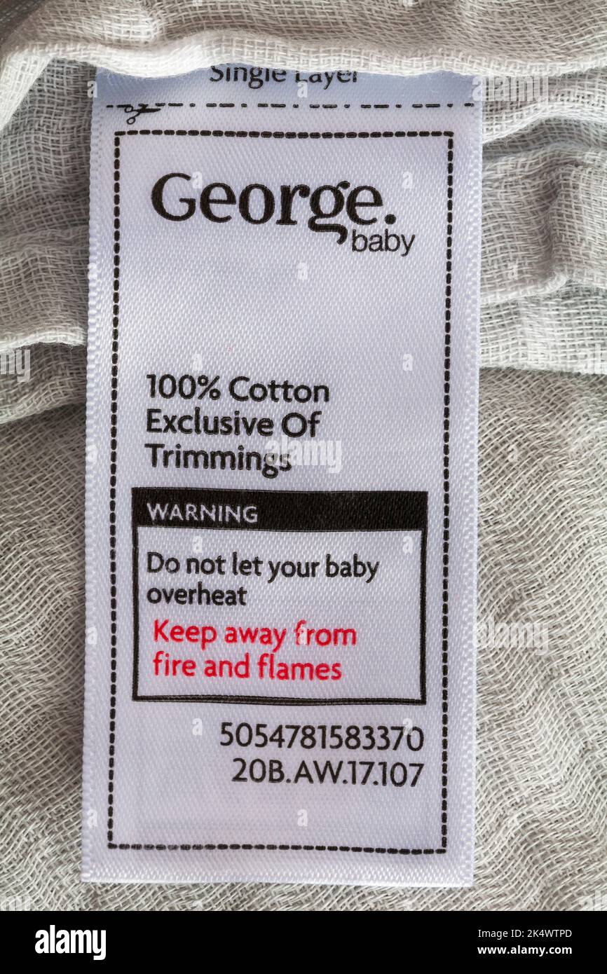 100% cotton exclusive of trimmings, do not let your baby overheat, keep away from fire and flames label in George baby cover Stock Photo