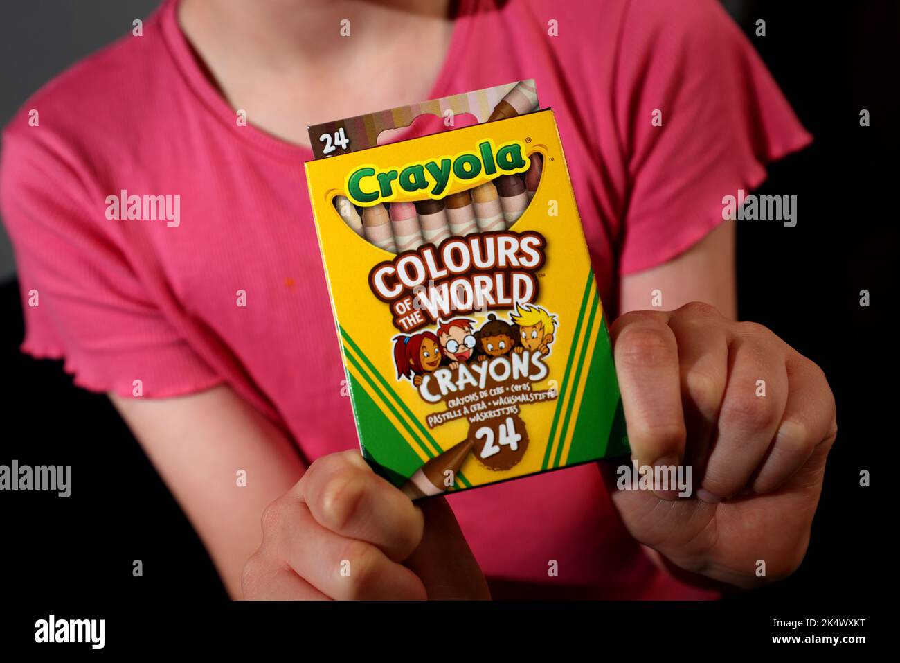 A young girl playing with some Crayola Colours of the World Book and Crayons in Chichester, West Sussex, UK. Stock Photo