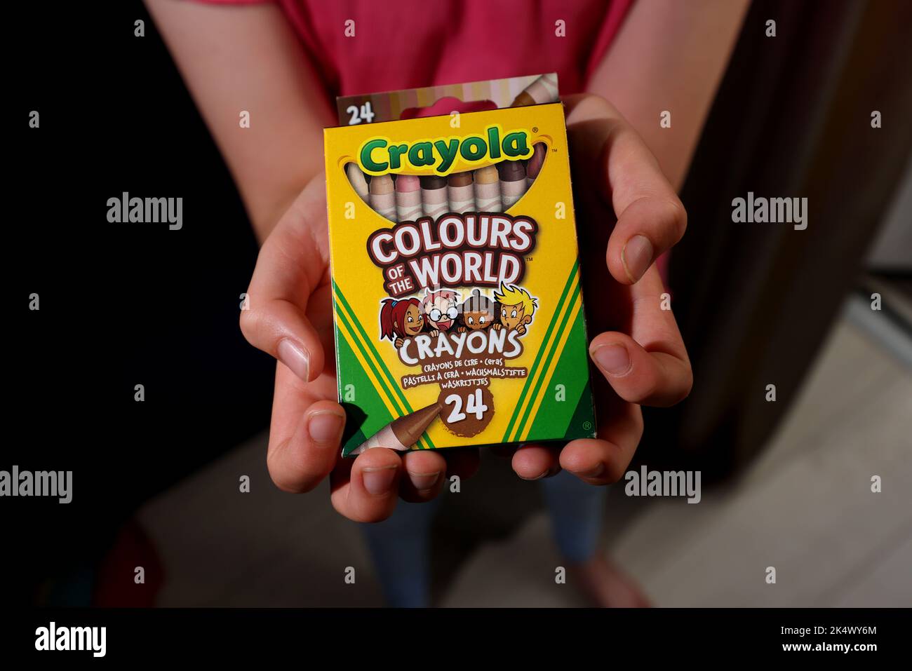 A young girl playing with some Crayola Colours of the World Book and Crayons in Chichester, West Sussex, UK. Stock Photo