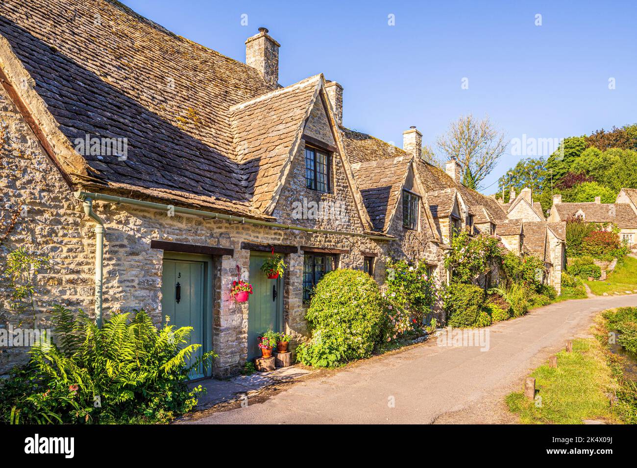 Early morning light in midsummer on Arlington Row in the Cotswold village of Bibury, Gloucestershire, England UK Stock Photo