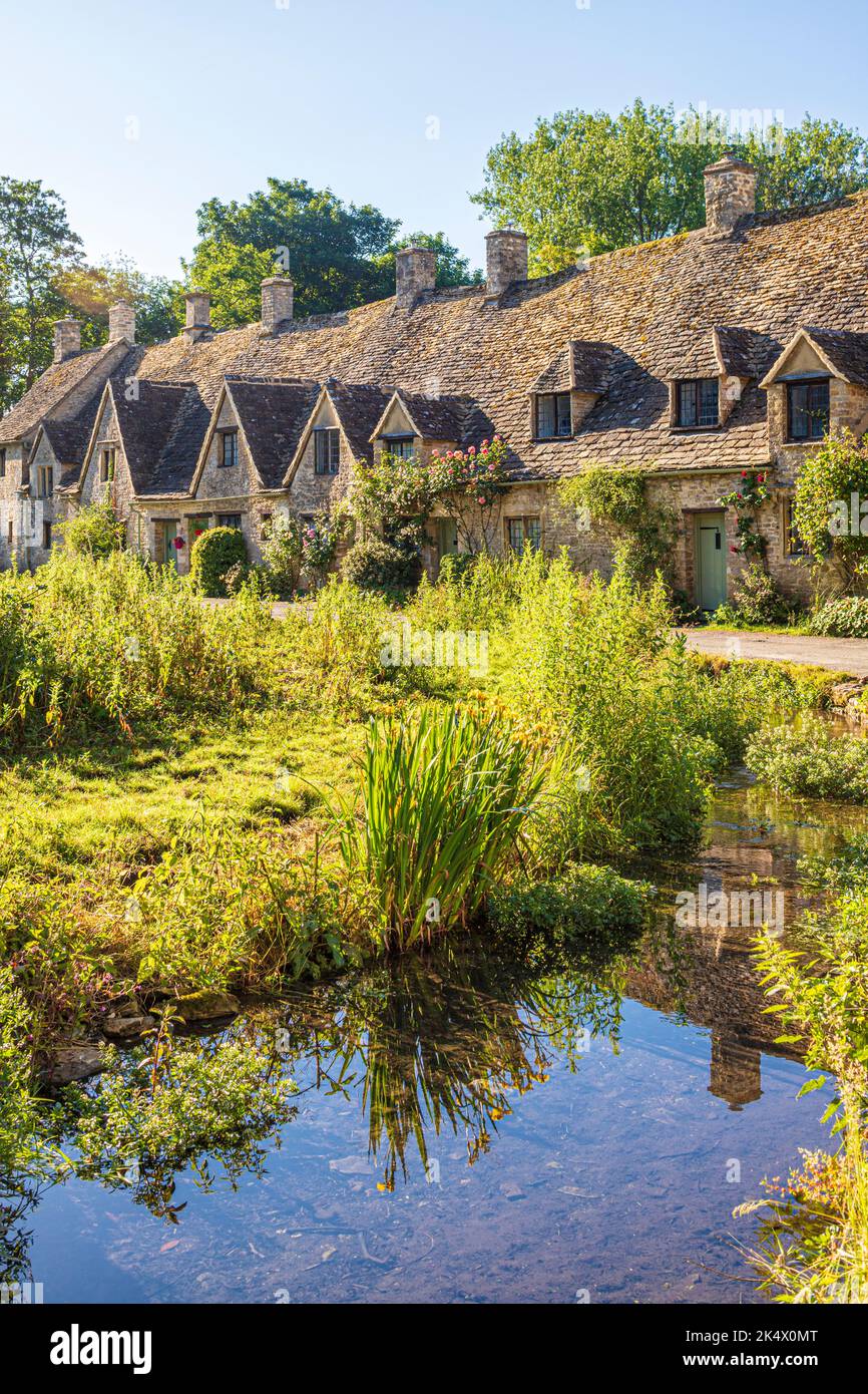Early morning light in midsummer on Arlington Row in the Cotswold village of Bibury, Gloucestershire, England UK Stock Photo