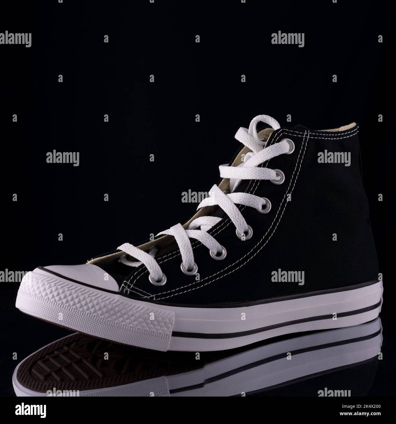 classic black sneakers on a black background Stock Photo