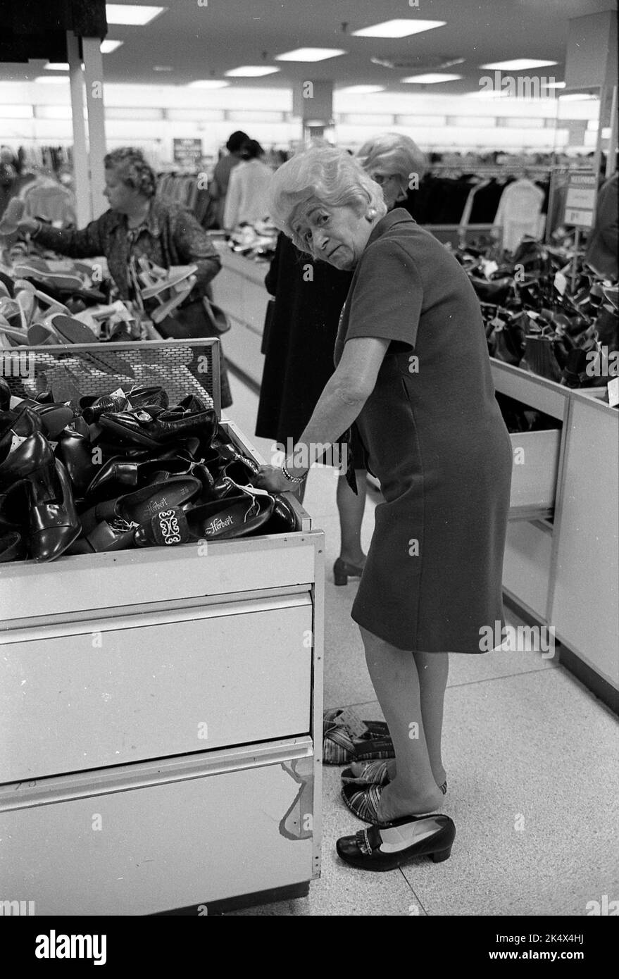 Old woman shopping shoes at a New York store, 1970 Stock Photo