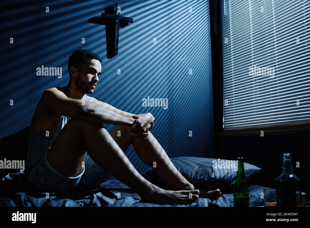 Sleeping Against Railing Young stressed man suffering from insomnia sitting on bed against wall ...