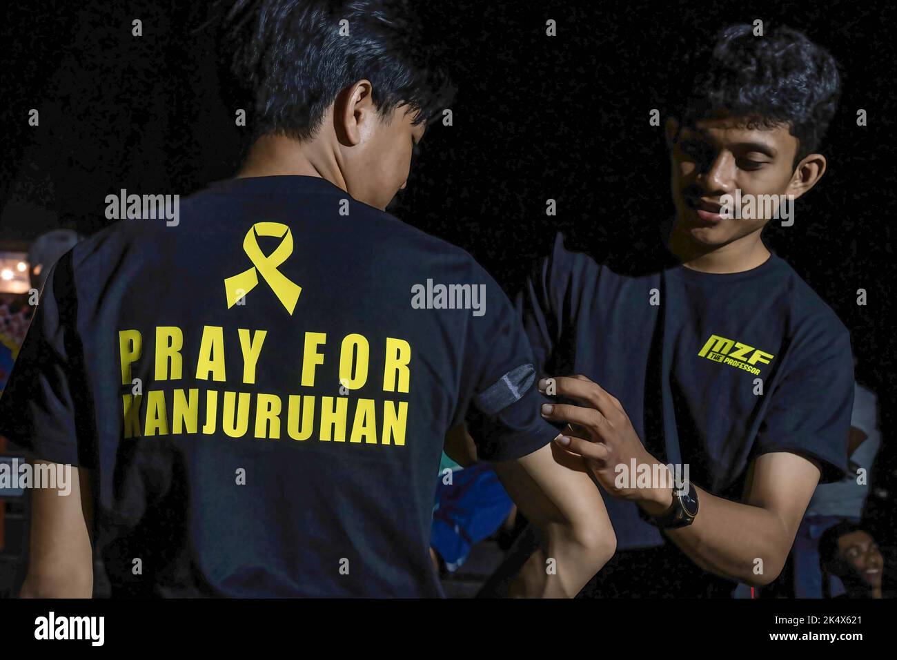 Kendari, Indonesia. 04th Oct, 2022. Soccer fans put black ribbons on