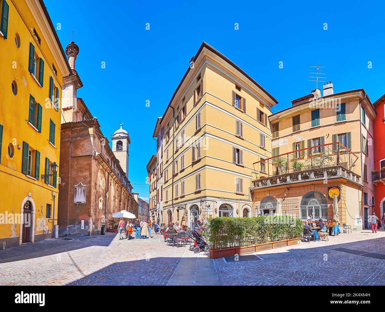 BRESCIA, ITALY - APRIL 10, 2022: The medieval houses with restaurants and bars on Via Gasparo da Salo street with stone building of San Giuseppe Churc Stock Photo