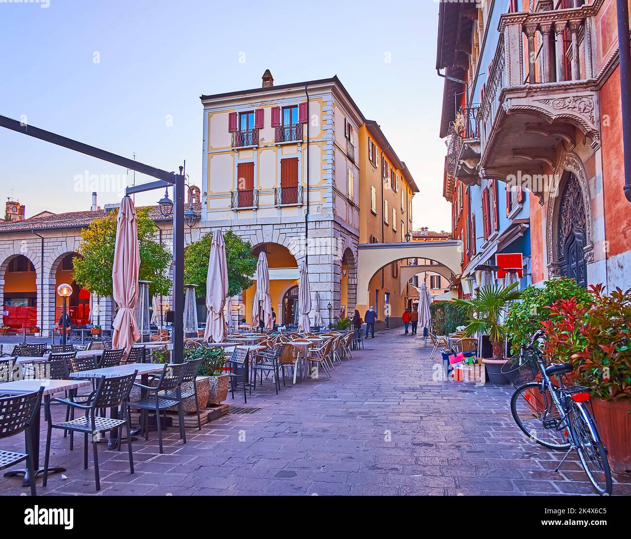 Historic buildings and line of outdoor restaurants around the Old Port (Porto Vecchio) of Desenzano del Garda, Lake Garda, Italy Stock Photo