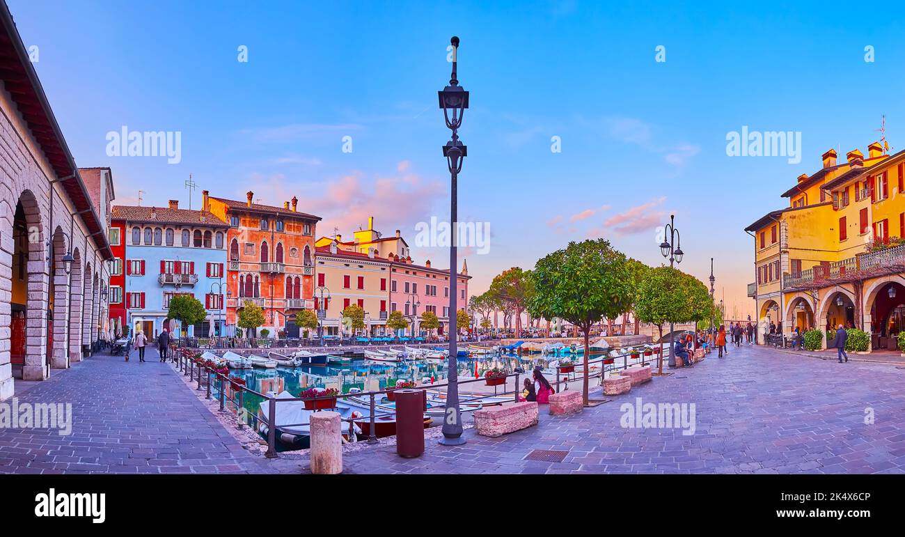 Enjoy the evening walk in Porto Vecchio (Old Port) with colored mansions around the port, Desenzano del Garda, Lake Garda, Italy Stock Photo