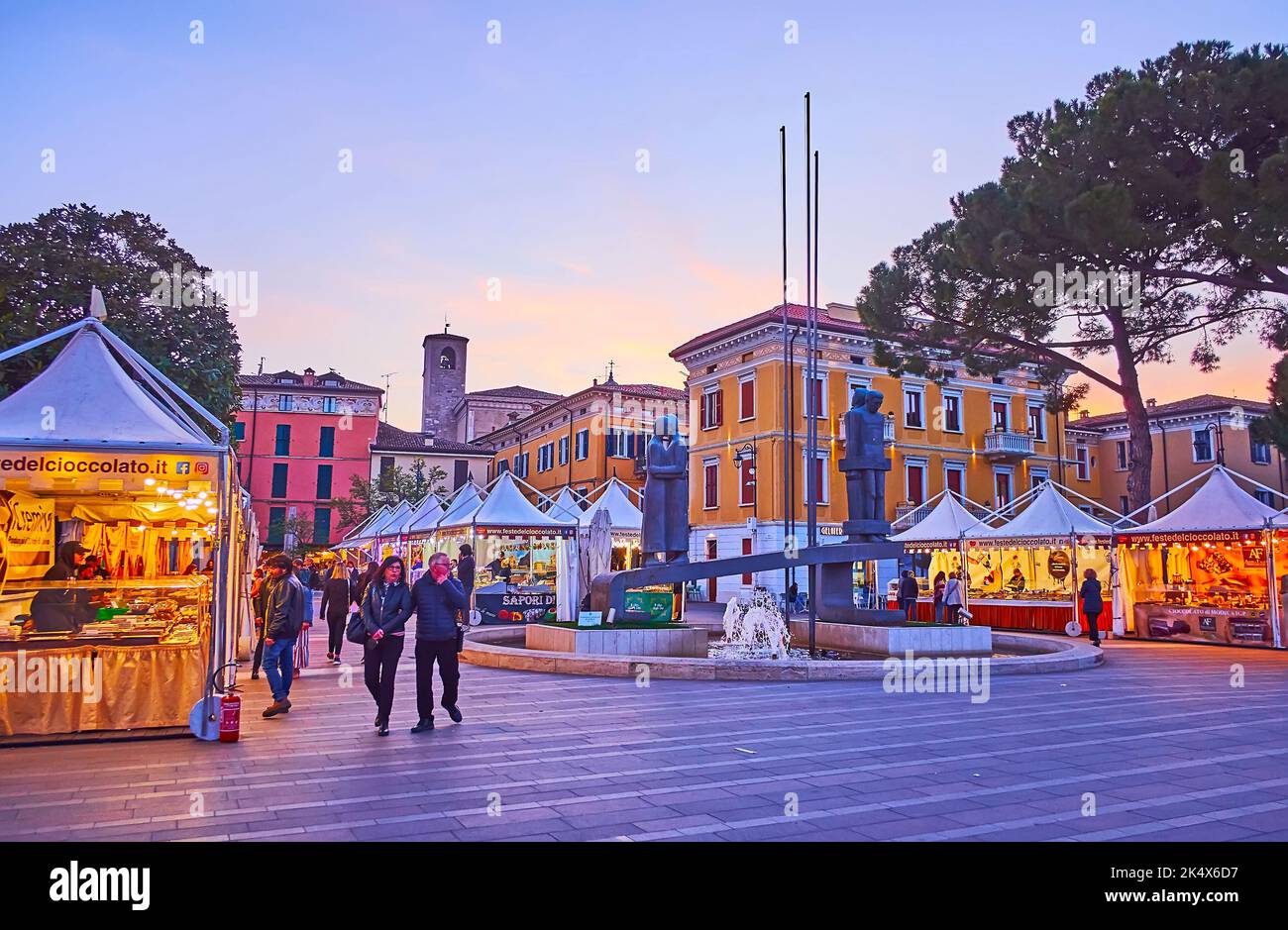 DESENZANO DEL GARDA, ITALY - APRIL 10, 2022: The evening Piazza Cappelletti with tents of tourist market and vintage houses, on April 10 in Desenzano Stock Photo