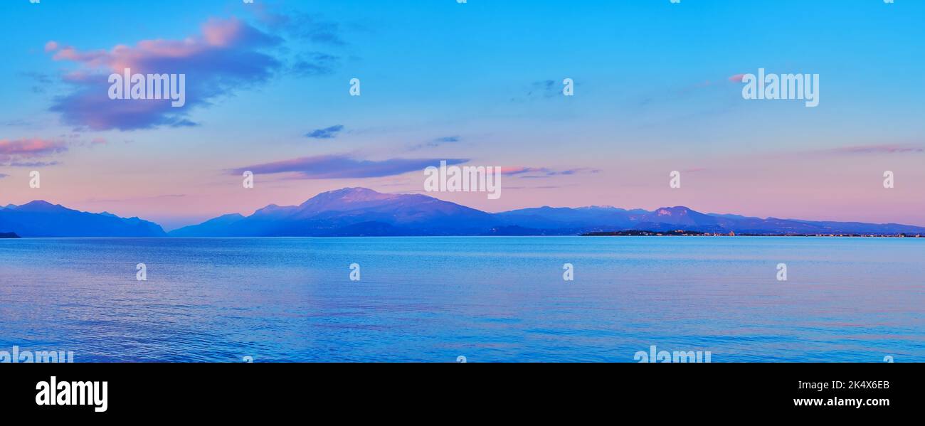 Panorama of beautiful shiny surface of Lake Garda at sunset, Desenzano del Garda, Italy Stock Photo