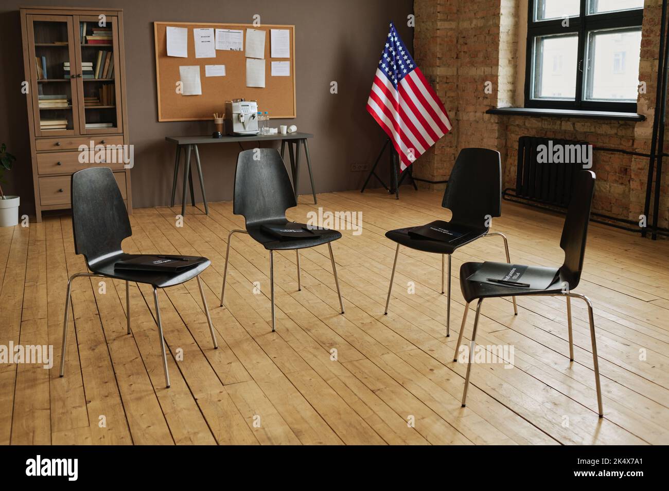 Several chairs making circle prepared for attendants of post traumatic syndrome support group in spacious studio with wooden floor Stock Photo