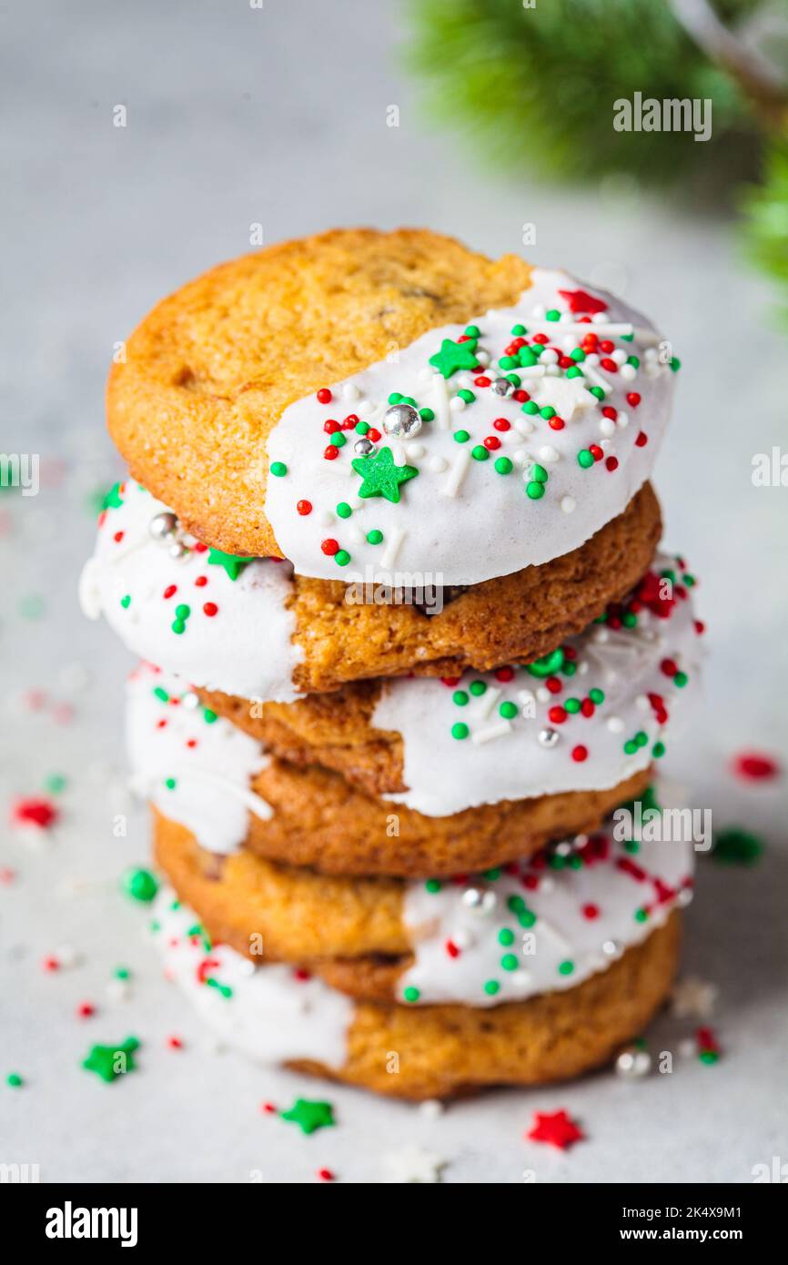 Stack of Christmas cookies with white frosting and holiday sprinkles. Stock Photo