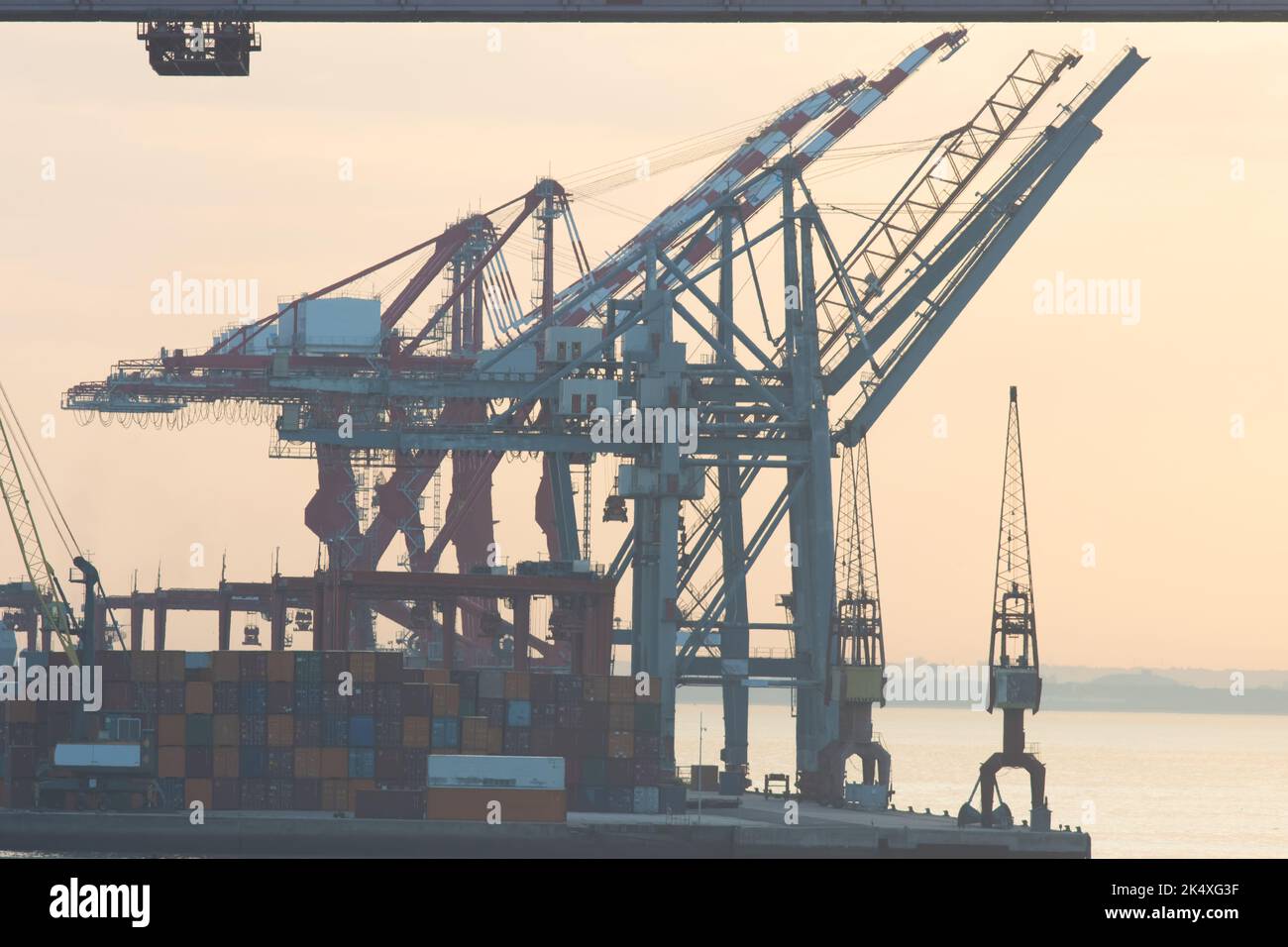 Sea cargo cranes in the port terminal of Lisbon, silhouette on sunrise Stock Photo