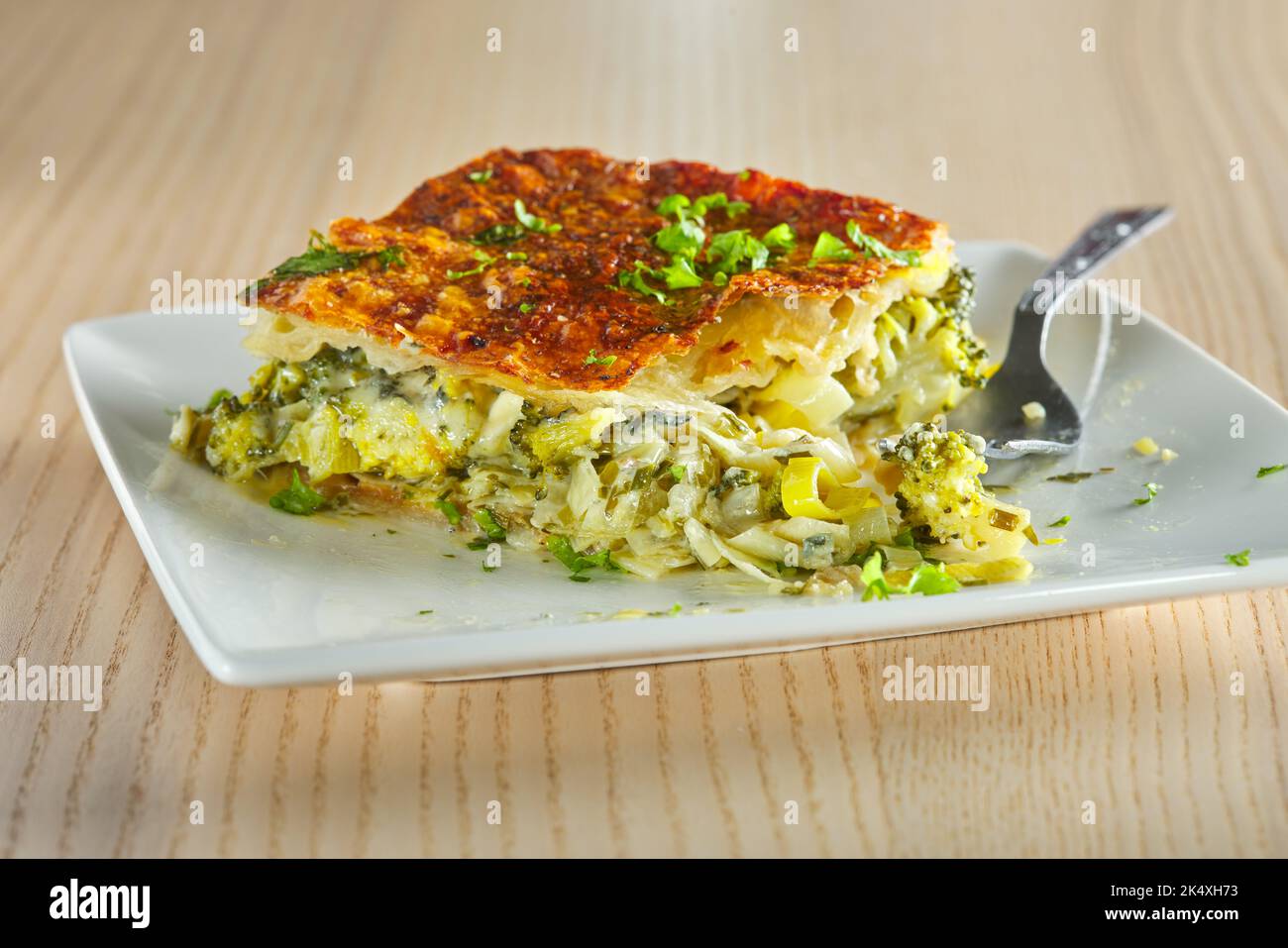 Eating from a pie made from broccoli, cheese, cream  and leek - close up view Stock Photo