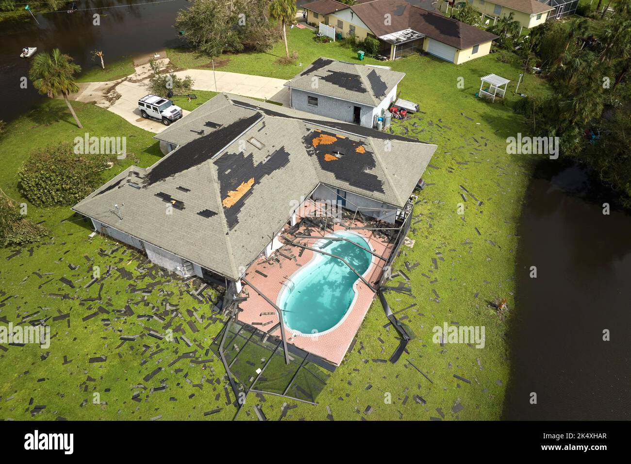 Hurricane Ian destroyed house roof in Florida residential area. Natural disaster and its consequences. Stock Photo