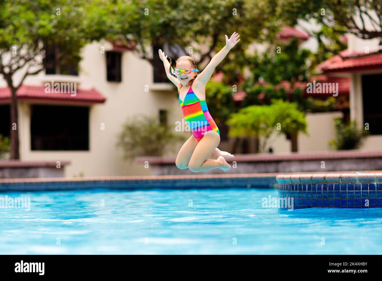 Child jumping and diving in swimming pool. Kids swim, jump and dive