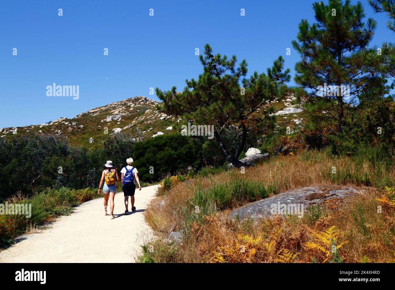 Tourists hiking on the trail up to the summit of Illa de Faro or Montefaro, Cies Islands, Galicia, Spain Stock Photo