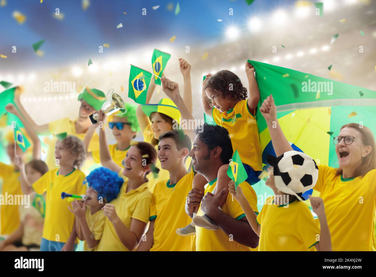 Brazil football supporter on stadium. Brazilian fans on soccer pitch watching team play. Group of supporters with flag and national jersey Stock Photo