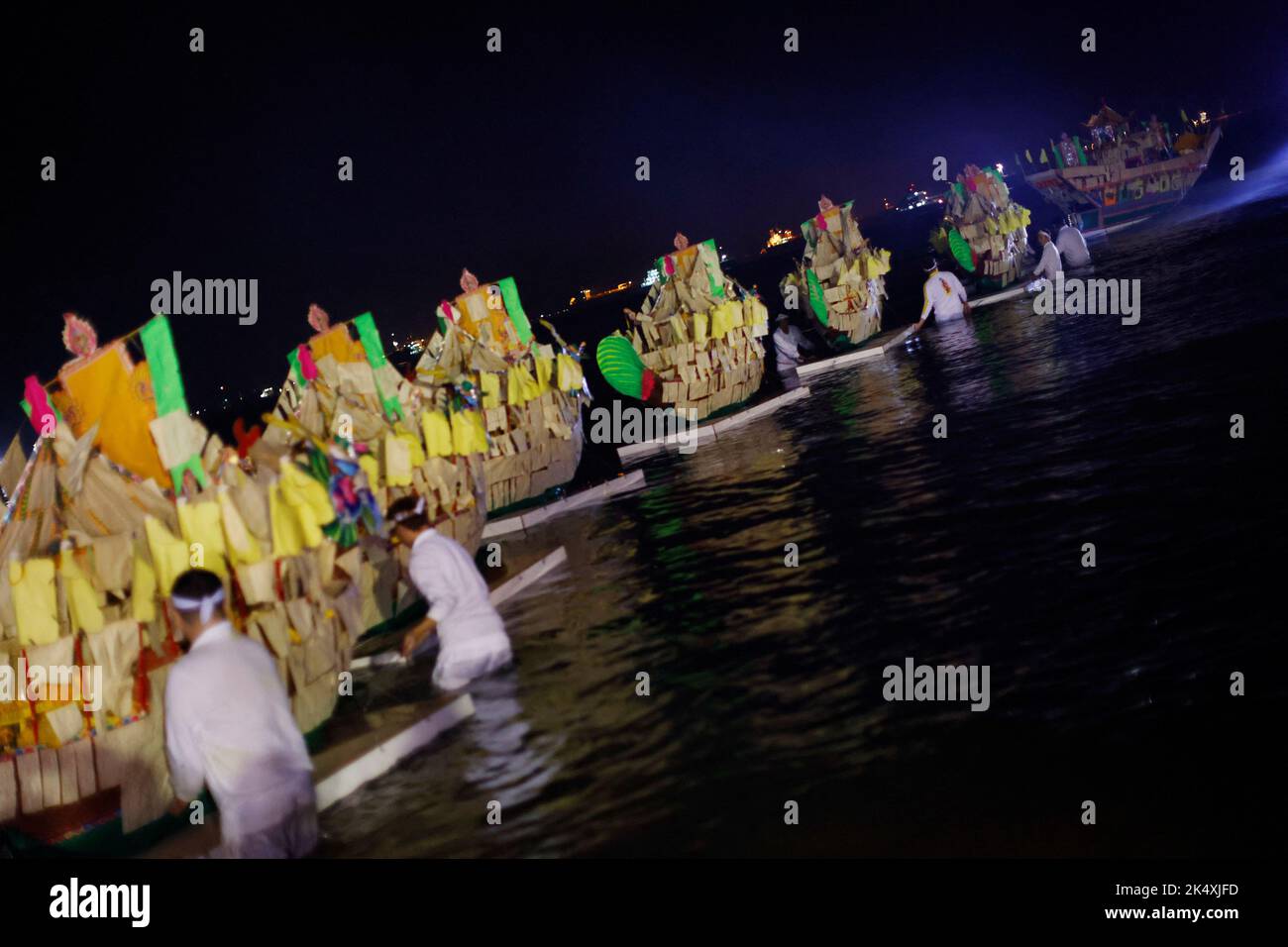 Devotees push off paper boats into the sea as they take part in a ritual to send off the gods during the last day of the Taoist Nine Emperor Gods festival in Singapore October 4, 2022. REUTERS/Edgar Su Stock Photo