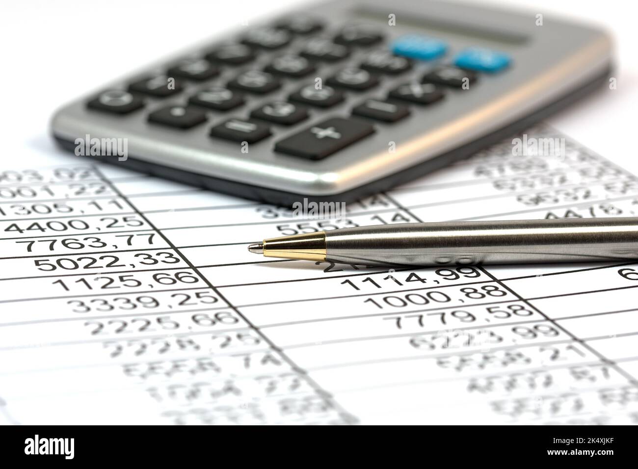List with numbers for calculation plus calculator and ballpoint pen