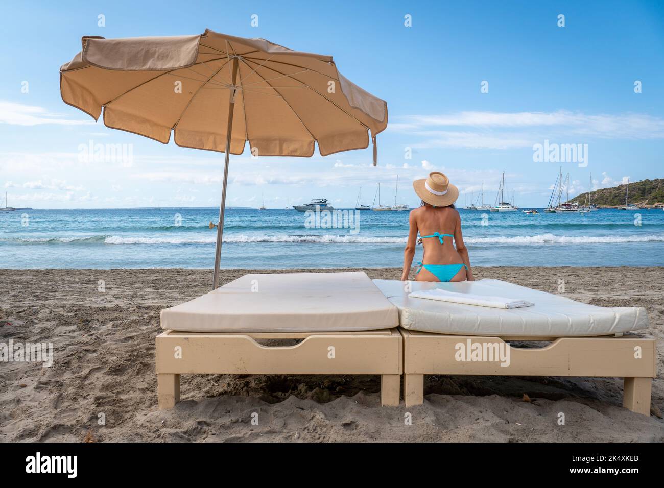 Lonely woman in bikini looking at the sea on a bed Stock Photo