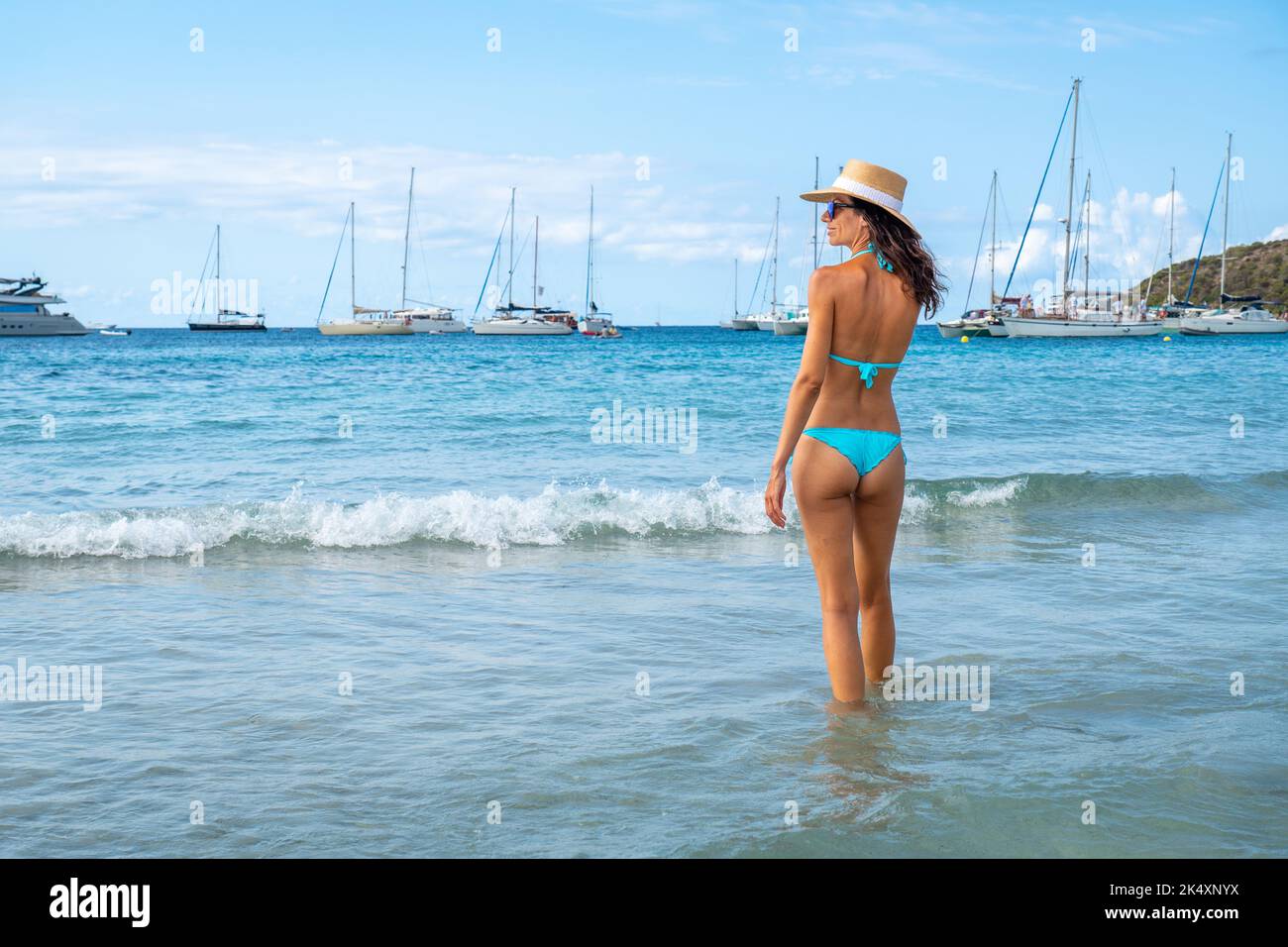 Woman with turquoise bikini and hat posing on a beach in Ibiza Stock Photo