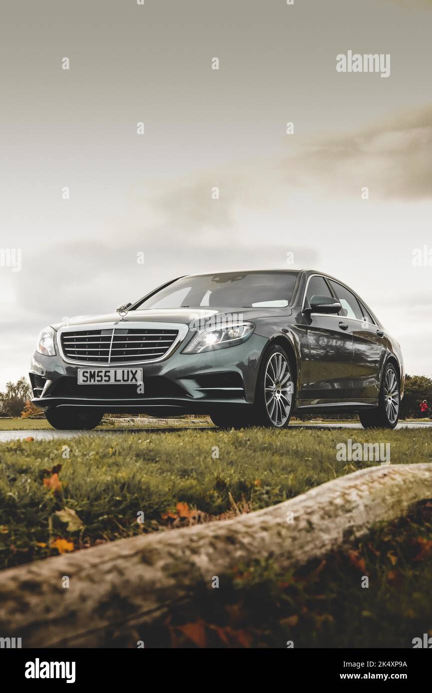 A black Mercedes Benz C-Class on a golf course against the sky Stock Photo