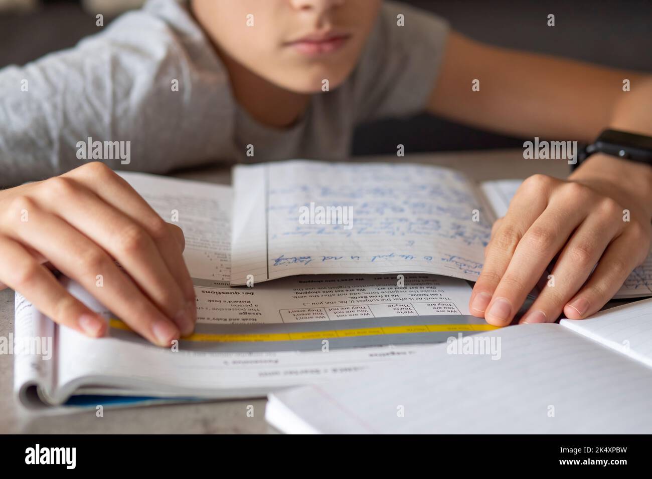 Kid affected by dyslexia doing homework, writing, reading notebook task