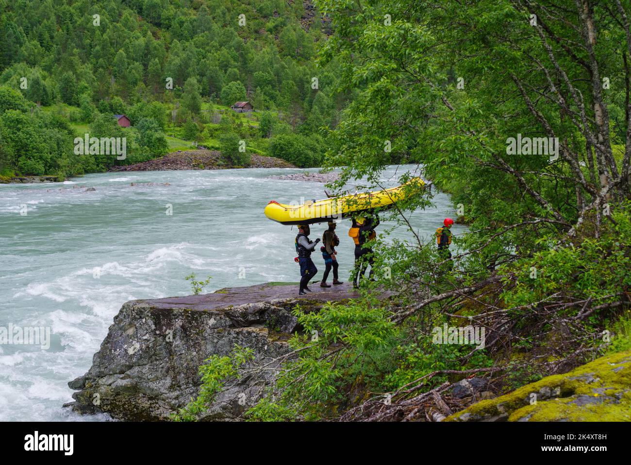 KROSSBU, NORWAY - JULY 3, 2022: Rafting team carrying their boat along a wild melt water river Stock Photo